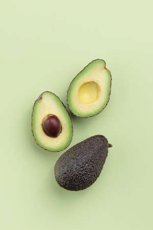 Avocado slices on a green background top view