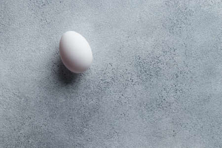 White egg on a concrete table top viewの写真素材