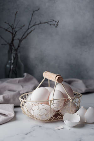 Spring time, easter holidays, white eggs in a basket gray background