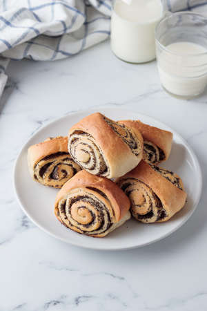Sweet homemade poppy seed buns with milk for the breakfastの写真素材