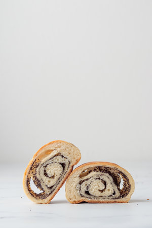 Homemade poppy seed roll buns on a white tableの写真素材