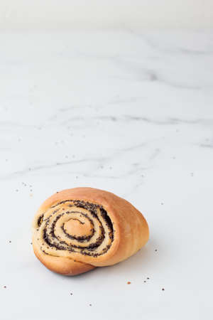 Homemade poppy seed roll buns on a white table