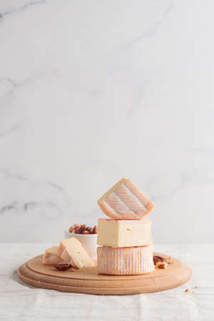 Sliced soft cheese with mold on a wooden board on a white backgroundの写真素材