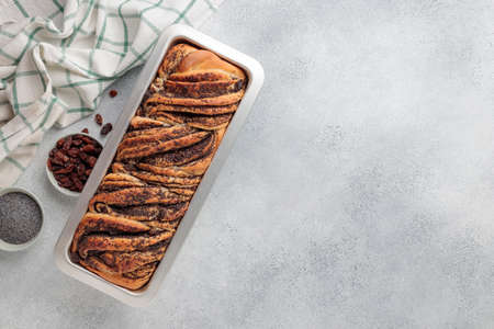 Sweet swirl homemade bread with poppy seeds on a gray concrete backgroundの写真素材