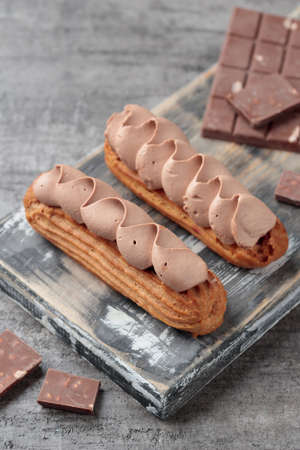 Traditional French dessert sweet eclairs on a gray background