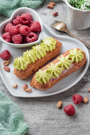 Traditional French dessert sweet eclairs on a gray background