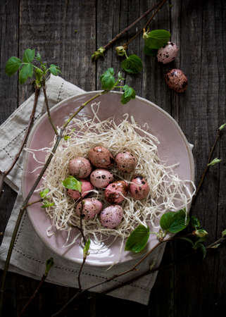 Quail eggs in a bowl top view on a wooden table