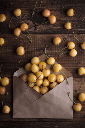 Yellow cherry on a wooden table top viewの写真素材