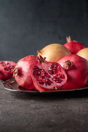 Ripe pomegranates on a dark table backgroundの写真素材