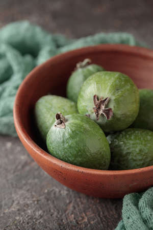 Feijoa in a bowl on dark tableの写真素材