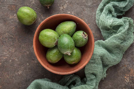 Feijoa in a bowl on dark tableの写真素材