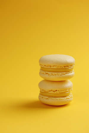 Lemon macaroons on a yellow background verticalの写真素材