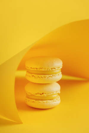 Lemon macaroons on a yellow background verticalの写真素材