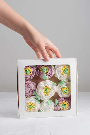 A gift box of zephyr flowers - marshmallow peonies on a white tableの写真素材