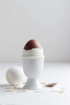 Chocolate egg on white eggs stand holder with copy space