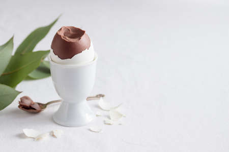 Started chocolate egg on white eggs stand holder with copy space