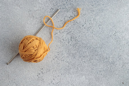 Crochet hook and a small ball of yellow yarnの写真素材