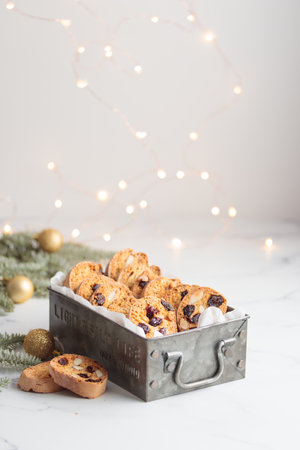 Biscotti in a metal box cantucci cookies with almond and cranberry on white background vertical photo banner with copy spaceの写真素材