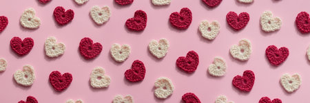 Crocheted amigurumi pink, red and white hearts on a pink background. Valentine's banner top viewの写真素材