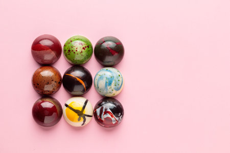 Assortment of handcrafted chocolate bonbons. Delicious dessert on a pink background banner with copyspaceの写真素材