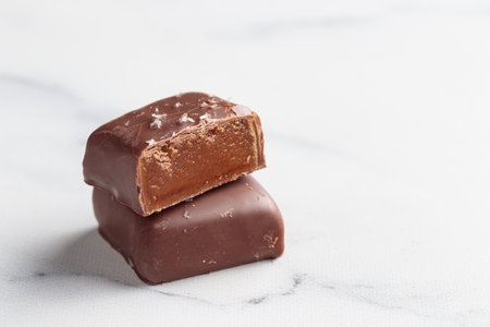 Chocolate handcrafted bonbons and cutted pieces of candy with praline and truffle on a white...