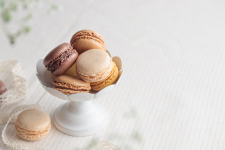Chocolate, vanilla, coffee eco handmade natural macaroons in a vase on white table. Gift for 8 March, International Women's Day, Valentine's Day. Horizontal banner closeup with a copyspaceの写真素材