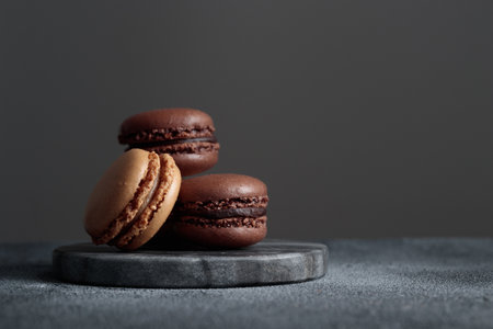 Chocolate eco handmade natural macaroons on dark background in the darkmood style. Horizontal banner top view with a copyspaceの写真素材