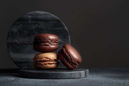 Chocolate eco handmade natural macaroons on dark background in the darkmood style. Horizontal banner top view with a copyspaceの写真素材