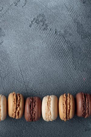 Colorful pastel eco handmade natural macaroons on dark background. Gift for 8 March, International Women's Day, Valentine's Day. Vertical banner top view with a copyspaceの写真素材