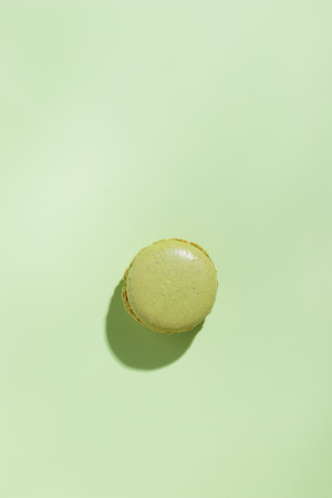 Green pistacio colored macaroon on green background. Gift for 8 March, International Women's Day, Valentine's Day. Horizontal banner with copyspaceの写真素材