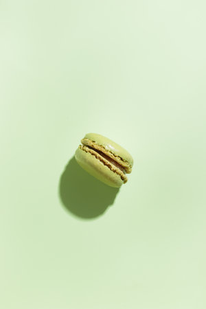 Green pistacio colored macaroon on green background. Gift for 8 March, International Women's Day, Valentine's Day. Horizontal banner with copyspaceの写真素材