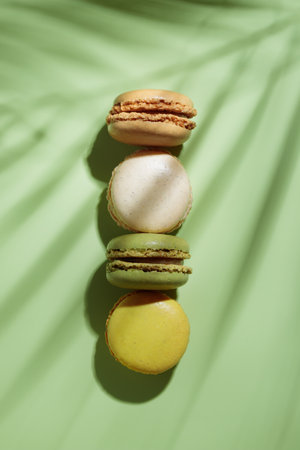 Colorful pastel eco handmade macaroons on green background with a shadow. Gift for 8 March, International Women's Day, Valentine's Day. vertical bannerの写真素材