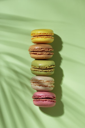 Colorful pastel eco handmade macaroons on green background with a shadow. Gift for 8 March, International Women's Day, Valentine's Day. vertical bannerの写真素材