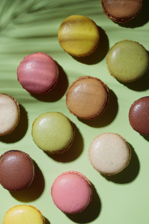 Colorful pastel eco handmade macaroons on green background with a shadow. Gift for 8 March, International Women's Day, Valentine's Day. vertical bannerの写真素材