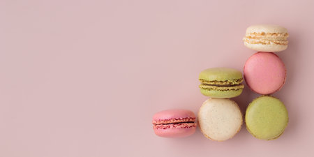 Colorful macaroons on pink background, top view, increase in profits of the confectionery production horizontal bannerの写真素材