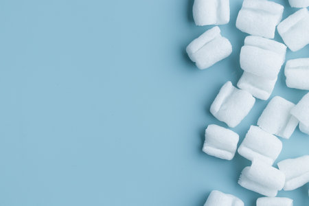 granules for filling boxe - reliable protective packaging solution, environmental friendly, fireproof and durable, shock-absorbing filler. Banner on a blue background with copyspaceの写真素材