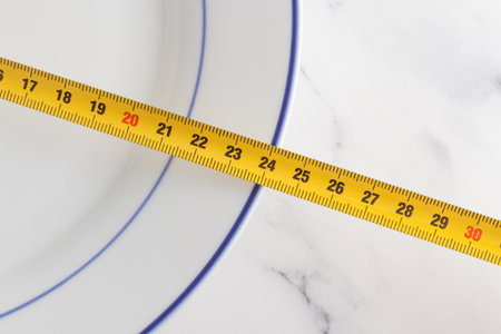 Size of white plate on a white background, measuring tapeの写真素材