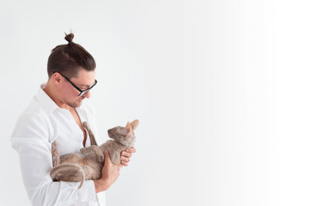 Joung man holding a cornish rex cat in his arms. Bannerの写真素材