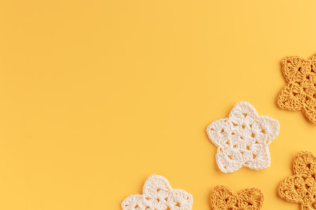 The white and yellow crocheted stars frame on a yellow background with copy spaceの写真素材