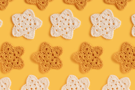 White and yellow crocheted stars pattern on a yellow backgroundの写真素材
