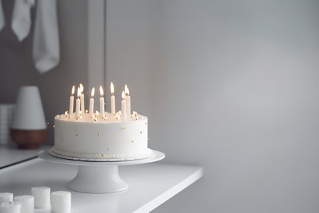 White and gold birthday cake with candles and sprinkles on the white table, minimalistic style with copy space. Generative AIの素材