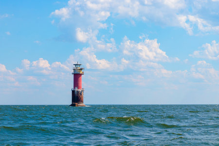 A lighthouse in the Baltic Sea in the Gulf of Finland near Tallinn, Estonia. Blue morning sky, clouds, waves, sea. Banner with copy spaceの写真素材