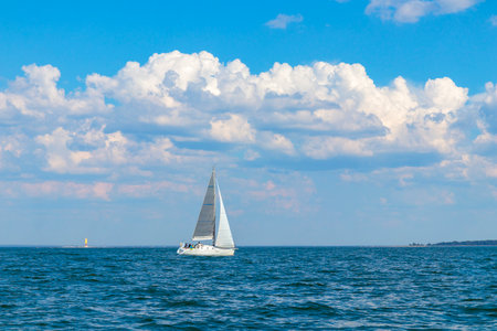 Yacht, white sailboat under head genoa and main sails sailing in an calm open sea. Cruise, vacations, regatta, sport. Gulf of Finlandの写真素材