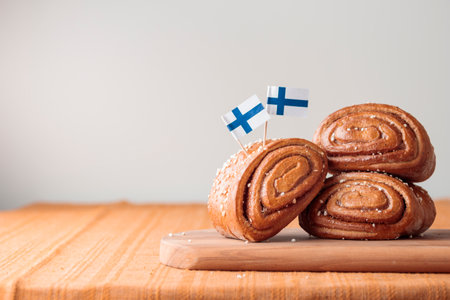 Korvapuusti, traditional Finnish cinnamon and cardamom rolls, fresh baked buns on the wooden board, sweet dessert Sweden and Finland, horizontal banner with copy space for holidayの写真素材