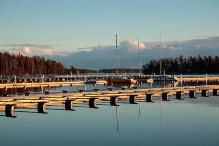 Sea marina in autumn, abandoned sailboats in a calm sea, empty marina harbor, autumn sailing season in Finland, Suomenojaの写真素材