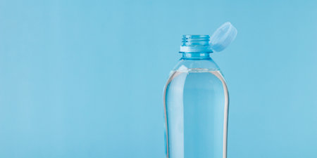 Bottle with a stationary plastic cap on a white background. The new design means the cap remains attached to the bottle after opening, making the entire package easier to collect and recycle. High-quality bannerの写真素材