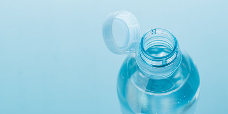Close up of new cap attached to plastic bottle, connected to the neck of the bottle by solid tab attached to safety ring. They are intended to encourage recycling, as part of the fight against litterの写真素材