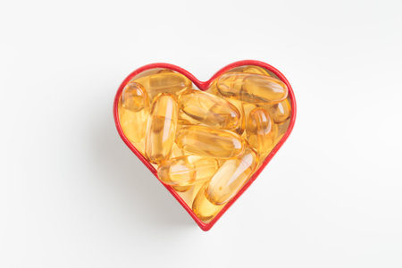 Yellow capsules arranged in a heart shape with red border on a white background. Contains vitamin...