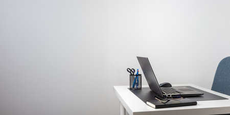 Laptop computer, notebook, and eyeglasses and headphones on a desk, place for work and study, home freelancer's office, no people.の写真素材