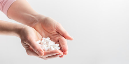 White pills in women's hands. Concept of health care, dietary supplements, treatment of depression and diseases. High-quality photo bannerの写真素材